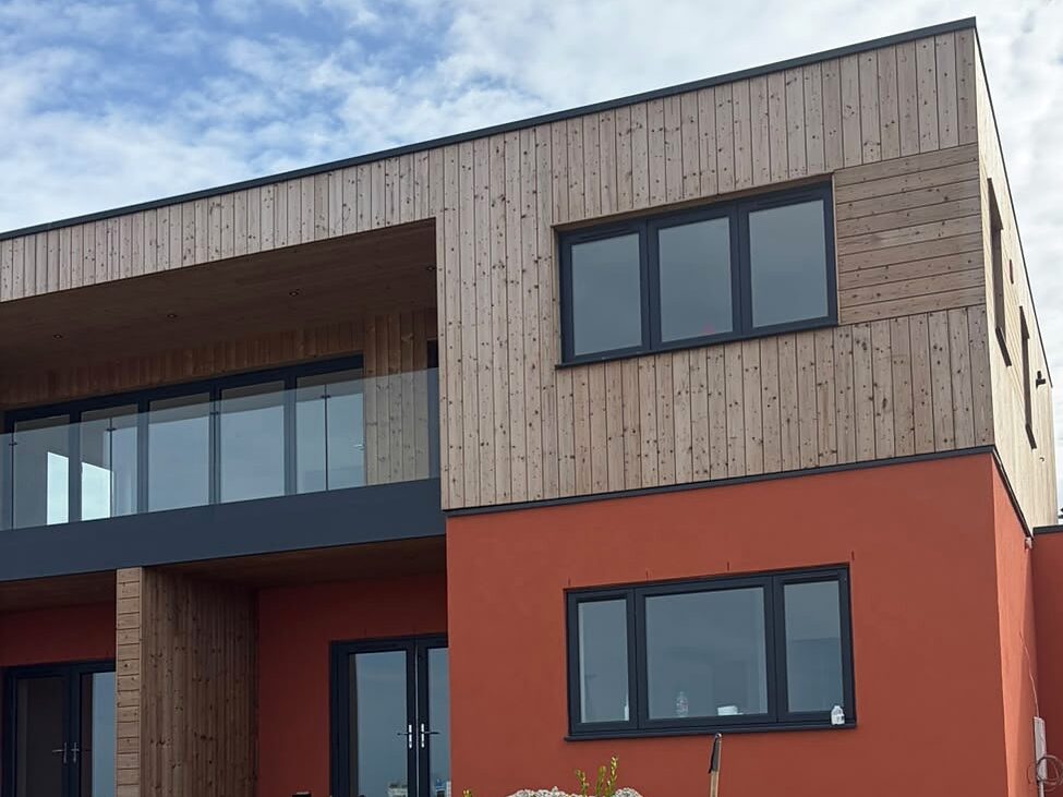 New-build house with a rendered ground floor and timber cladding above